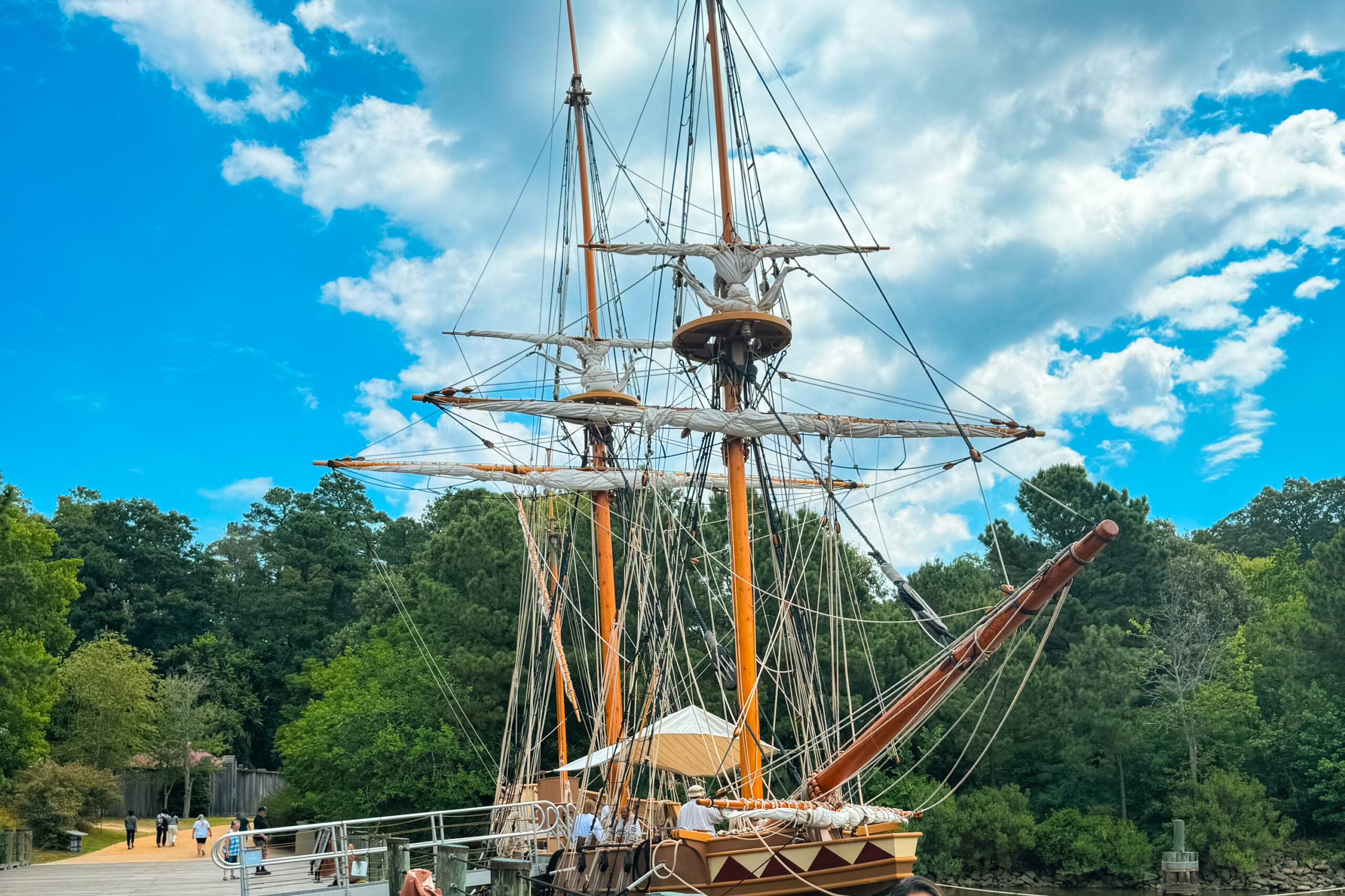 Families exploring recreated colonial structures and historic ship replicas at Jamestown Settlement, a living history museum.