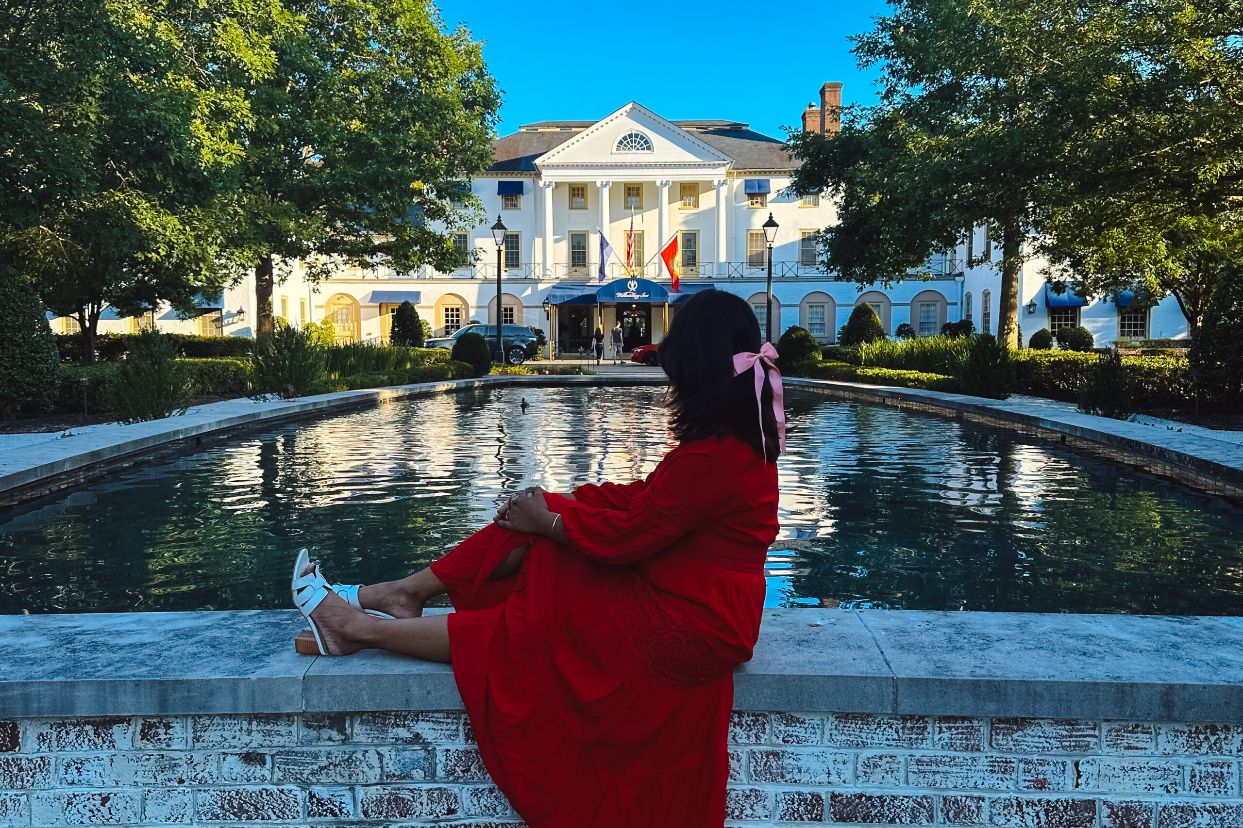 A luxurious family suite at the Williamsburg Inn, showcasing elegant decor and a view of lush, family-friendly outdoor spaces.