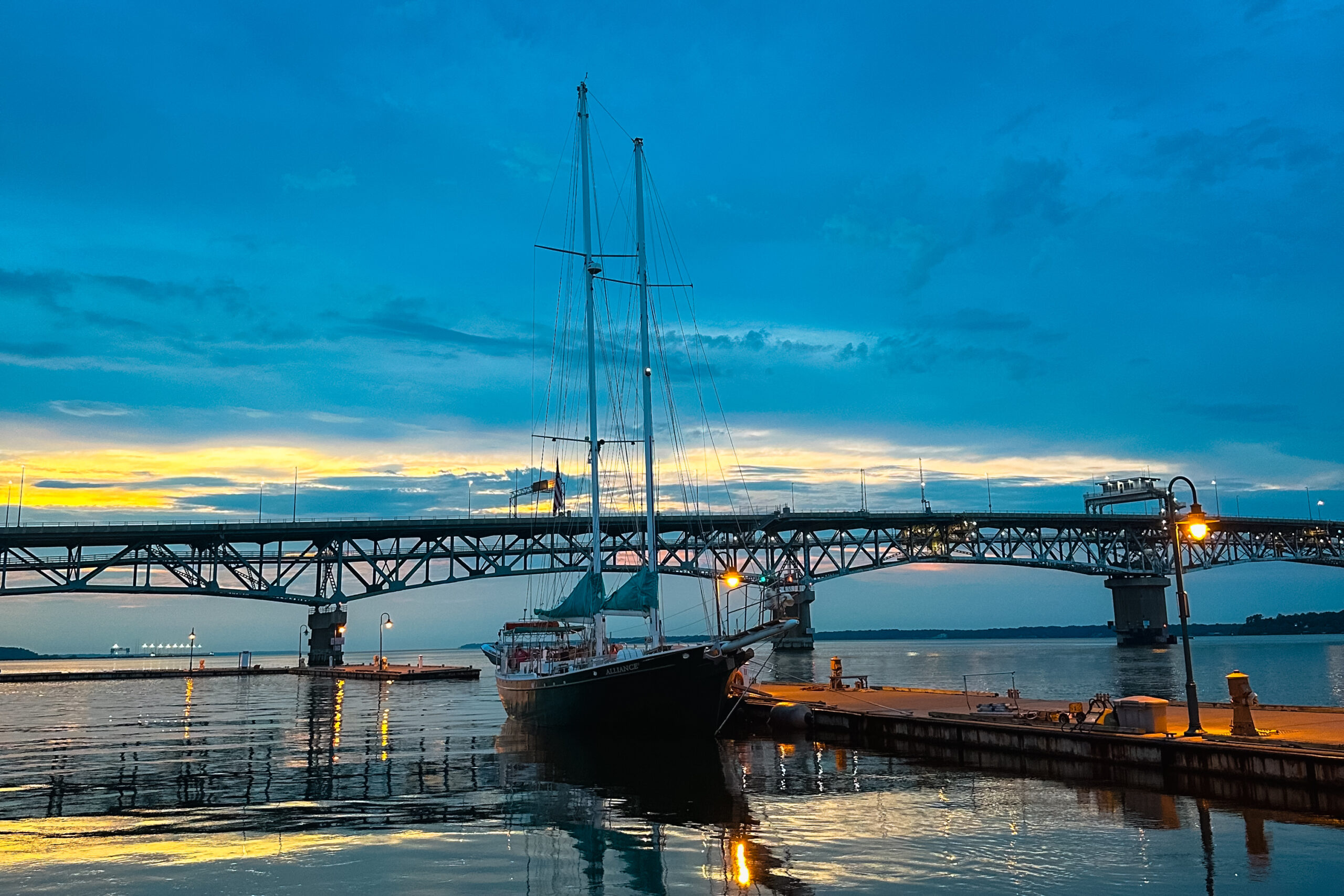 Sailing on a beautiful sunset cruise in Yorktown, Virginia, with views of the waterfront and the sky painted in warm colors.